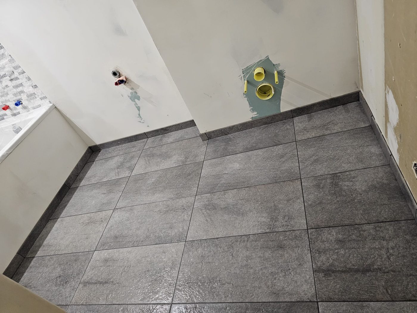 Sol en grands carreaux carrés gris posé dans une salle de bain